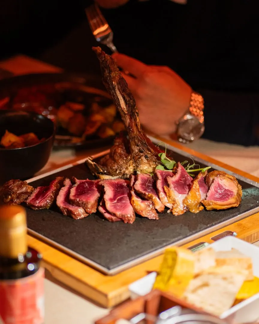 Costata con l'osso tagliata a fette e servita su pietra